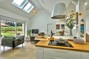 a kitchen and living room with a stove top oven at La longère de Poulrinou in Bohars