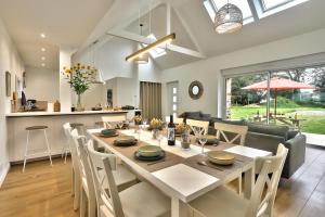 een eetkamer en keuken met een tafel en stoelen bij La longère de Poulrinou in Bohars