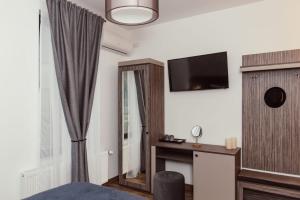 una habitación de hotel con una cama y un televisor en Poiana Verde Garden House, en Poiana Campina