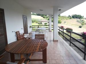 eine Terrasse mit einem Holztisch und Stühlen auf dem Balkon in der Unterkunft Villa Assunta con piscina in Benevento