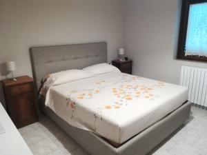 a bedroom with a white bed with flowers on it at Villa Assunta con piscina in Benevento +11 photos