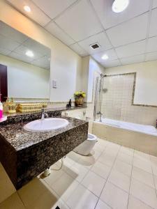 a bathroom with a sink and a toilet and a mirror at Marina Homes in Dubai