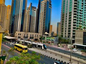 a city with a train on a street with tall buildings at Marina Homes in Dubai