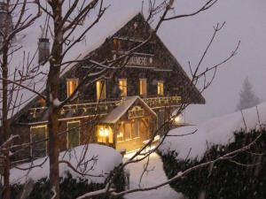 ein großes Haus mit Licht im Schnee in der Unterkunft La Chaumiere - Luxury Traditional Chalet, Châtel in Châtel