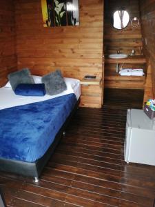 um quarto com uma cama num quarto de madeira em Breeze Glamping -Guatape em El Peñol