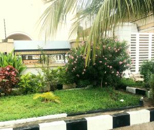 a garden with flowers and plants in front of a building at Somewhere Apartment in Gwarinpa