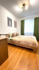 um quarto com uma cama grande e cortinas verdes em 3 кімнатна затишна та комфортна квартира em Chernivtsi