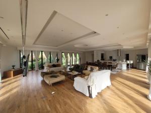 a large living room with white furniture and wooden floors at Maison 12 personnes, Vendée et puy du fou in Treize-Septiers