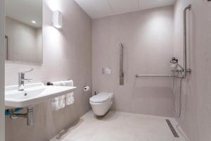 a bathroom with a toilet and a sink and a shower at Uma Suites O'Donnell in Madrid