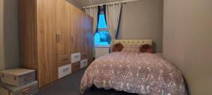 een slaapkamer met een bed, een dressoir en een raam bij A home away from home in Torquay