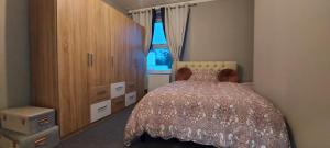 a bedroom with a bed and a dresser and a window at A home away from home in Torquay