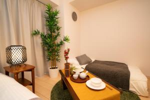 ein Wohnzimmer mit einem Bett und einem Couchtisch in der Unterkunft shinjuku1 in Tokio