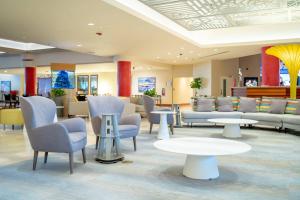 a waiting room with chairs and tables in a lobby at Courtyard by Marriott Isla Verde Beach Resort in San Juan