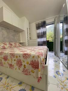 1 Schlafzimmer mit einem Bett mit Blumenbettdecke in der Unterkunft Il Borgo in Sant'Egidio del Monte Albino