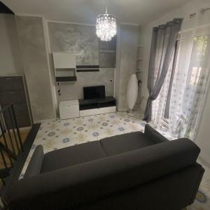 ein Wohnzimmer mit einem Sofa und einem TV in der Unterkunft Il Borgo in Sant'Egidio del Monte Albino
