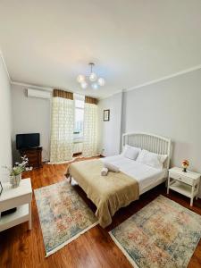 1 dormitorio con 1 cama y 2 alfombras en Apartment Olymp Palace at left coast in Astana, en Taldykolʼ