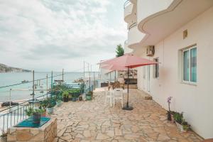 a patio with an umbrella and a view of the water at Beachfront Apartment in Himare