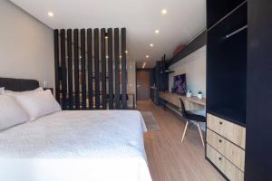 a bedroom with a bed and a desk in a room at Loft 508 Inn - Parque Una in Pelotas