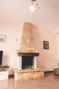 una chimenea de piedra en la sala de estar con una lámpara de araña en Beachfront Apartment, en Himare