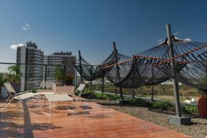 a patio with chairs and hammocks on a roof at Loft 508 Inn - Parque Una in Pelotas