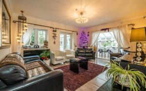 a living room with a leather couch and chairs at Westwood Guest House - Room Only in Lyme Regis