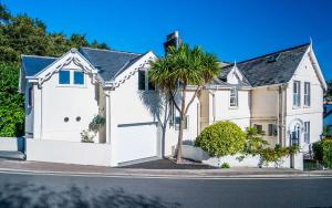 a white house with a palm tree in front of it at Westwood Guest House - Room Only in Lyme Regis