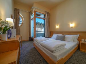 a bedroom with a large bed and a window at Hotel Club Uappala Sestriere in Sestriere