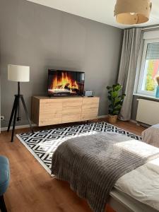 1 dormitorio con TV y 1 cama con chimenea en Haus Gitta - Wohlfühlen & Genießen, en Luckenwalde