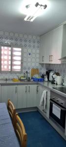 a kitchen with white cabinets and a table and a stove at Trandelu in Daimuz