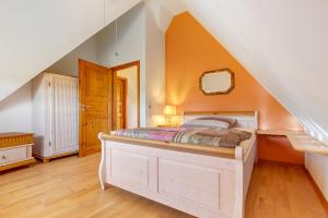 een slaapkamer met een bed met een oranje muur bij Ferienwohnung im Grünen in Bissendorf