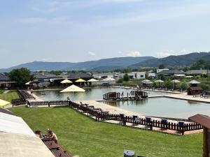 a large swimming pool with people sitting in the grass at Penzion u Tučňaka in Humenné