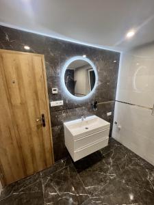 a bathroom with a sink and a mirror at Penzion u Tučňaka in Humenné