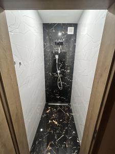 a bathroom with a black marble floor and white walls at Penzion u Tučňaka in Humenné