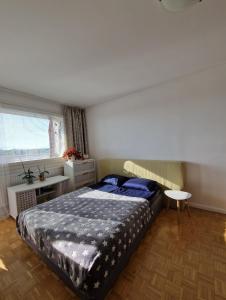 a bedroom with a bed and a table and a window at Big room with balcony in a shared apartment in the center of Kerava in Kerava