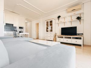ein weißes Wohnzimmer mit einem Flachbild-TV in der Unterkunft Charming & Sunny Apartment with Ocean View in Adeje