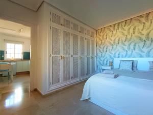 ein Schlafzimmer mit einem weißen Bett und einem Wandbild in der Unterkunft Charming & Sunny Apartment with Ocean View in Adeje