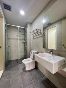a bathroom with a toilet and a sink and a shower at TWC Luxury Seaview Suites Bali Residences Malacca in Melaka