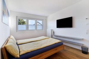 a bedroom with a bed and a flat screen tv at Wolf's Apartment Schwarzwald in Renchen