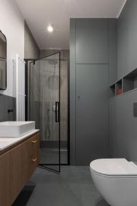 a bathroom with a shower and a toilet and a sink at Solidarność Three Bedroom & Garden Apartment in Gdańsk