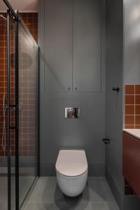 a bathroom with a toilet and a shower at Solidarność Three Bedroom & Garden Apartment in Gdańsk