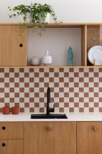 a kitchen with a sink and a checkered wall at Solidarność Three Bedroom & Garden Apartment in Gdańsk