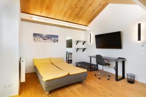 a bedroom with a bed and a desk and a tv at Wolf's Apartment Ortenau in Renchen