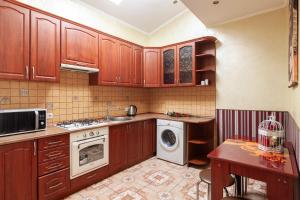リヴィウにあるAlfa Apartments Ohiienka 17 2のキッチン(木製キャビネット、洗濯機、乾燥機付)