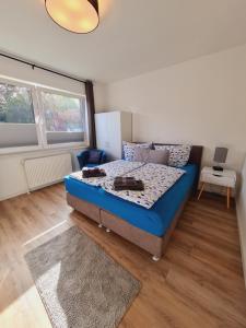 a bedroom with a blue bed in a room at Apartmenthaus am Park in Wilhelmshaven