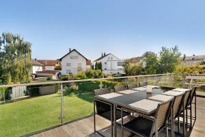 a table and chairs on a balcony with a garden at Wolf's Apartment Ortenau in Renchen +8 photos