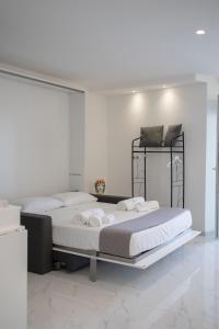 a white bedroom with a large bed with towels on it at U Scrusciu d’u Mari Luxury Suite in Cefalù