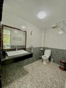 a bathroom with a tub and a toilet and a mirror at Voi Hostel in Mèo Vạc