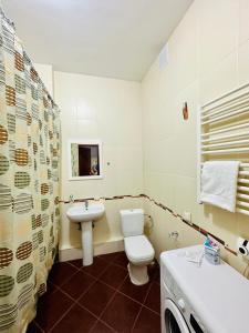 y baño con aseo blanco y lavamanos. en Apartment Olymp Palace at left coast in Astana, en Taldykolʼ