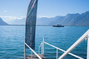 una barca in acqua con una barca sullo sfondo di JETTY Montreux a Montreux