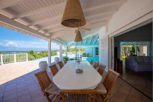 een eetkamer met een witte tafel en stoelen bij Villa La Josephine, Terre Basses in Baie Longue